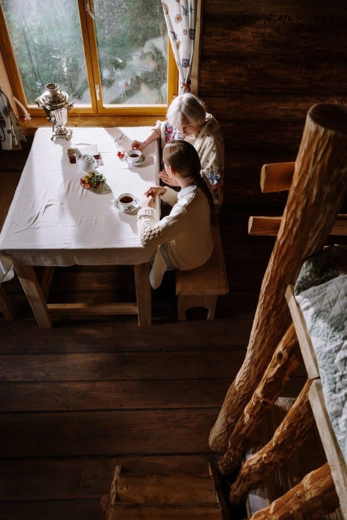 una abuela y su nieto desayunando en una casa rustica